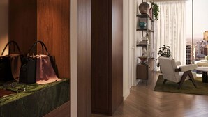 Un salon moderne avec un plancher en bois, un tapis à rayures, un canapé, une table basse et une bibliothèque agrémentée d’objets décoratifs.