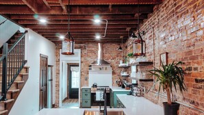 A kitchen with a brick wall, wooden beams, and pendant lights. - Twin Bricks Railhouse near Route 66 (Bourbon)