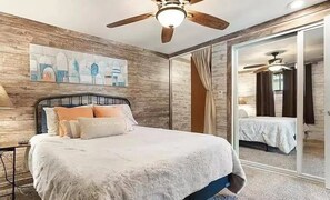 A bedroom with a bed, a ceiling fan, a painting on the wall, and a sliding glass door leading to another room. - 4 Beds 2.5 Baths  Sleeps 10 Lakeview ,Priv, Dock, Boat Slip, Sunrise Beach (Sunrise Beach)