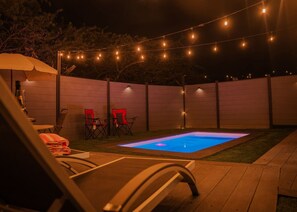 A backyard with a pool, lounge chairs, and string lights. - Cozy 2BR Villa• Private Pool and Patio• Hot water• Aruba Tropical Getaway (Oranjestad)