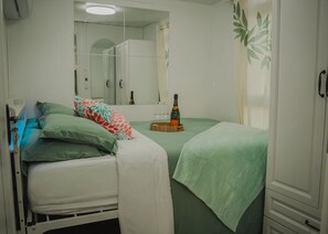A room with two beds, a mirror, a bottle of champagne, and a wooden tray. - Cozy 2BR Villa• Private Pool and Patio• Hot water• Aruba Tropical Getaway (Oranjestad)