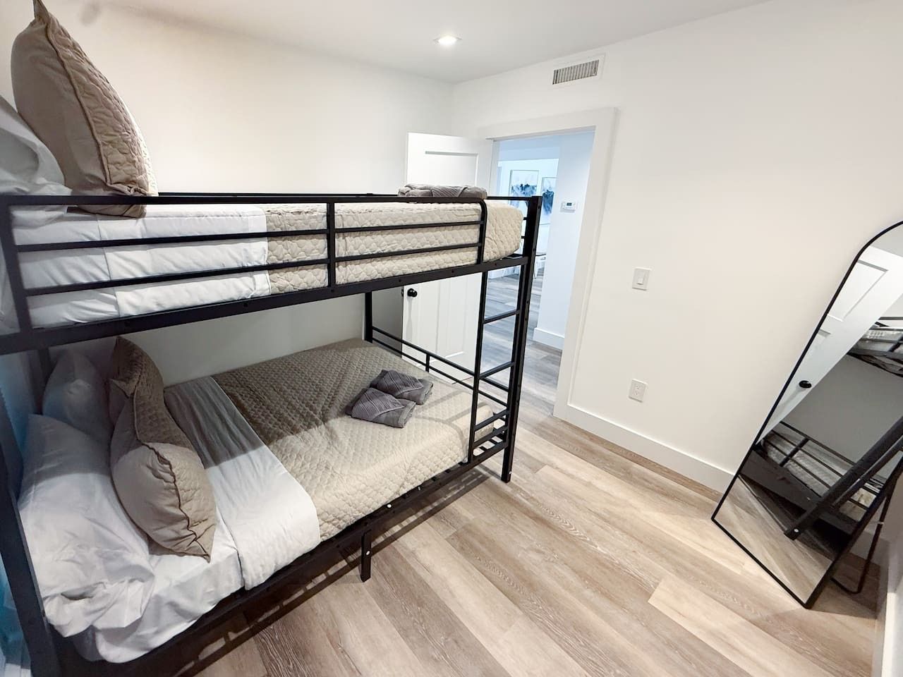 Ein Stockbett in einem Zimmer mit Holzboden und weißen Wänden.