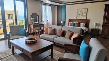 Suite estudio Deluxe, balcón, vistas parciales al mar | Zona de estar | Una televisión de pantalla plana, Netflix, servicios de streaming