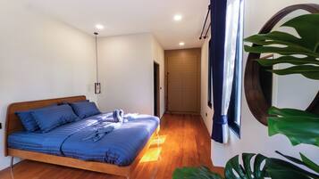 A modern bedroom with a wooden bed, a large window with curtains, and a potted plant.