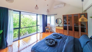 Un dormitorio amplio con una cama grande, un armario de madera y un ventilador de techo.
