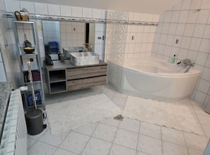 A modern bathroom with a freestanding bathtub, a vanity with a marble countertop, and a glass shelving unit. - Villa Bella Vista (Ivanec)