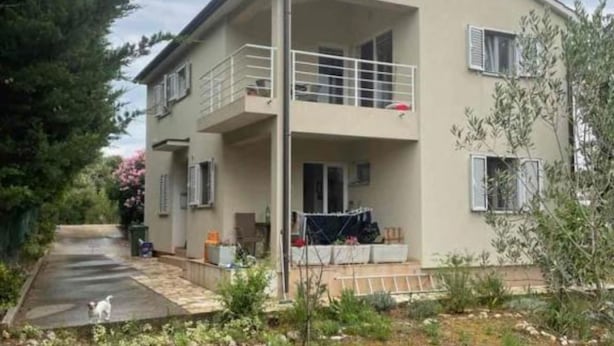 A two-story building with a balcony on the upper floor, a covered outdoor seating area, and a paved driveway. - Family House Kurtin by Brankica (Preko)