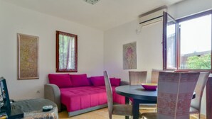 Une pièce comprenant un canapé, des fauteuils, une table et des œuvres d’art accrochées aux murs.