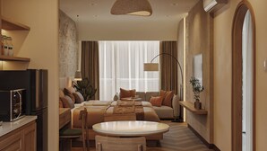 Een moderne hotelkamer met een zithoek, een zachte zithoek, een televisie en een kitchenette.