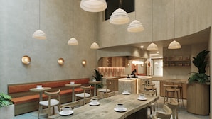 Een modern café met houten tafels en stoelen, een bar en hanglampen.