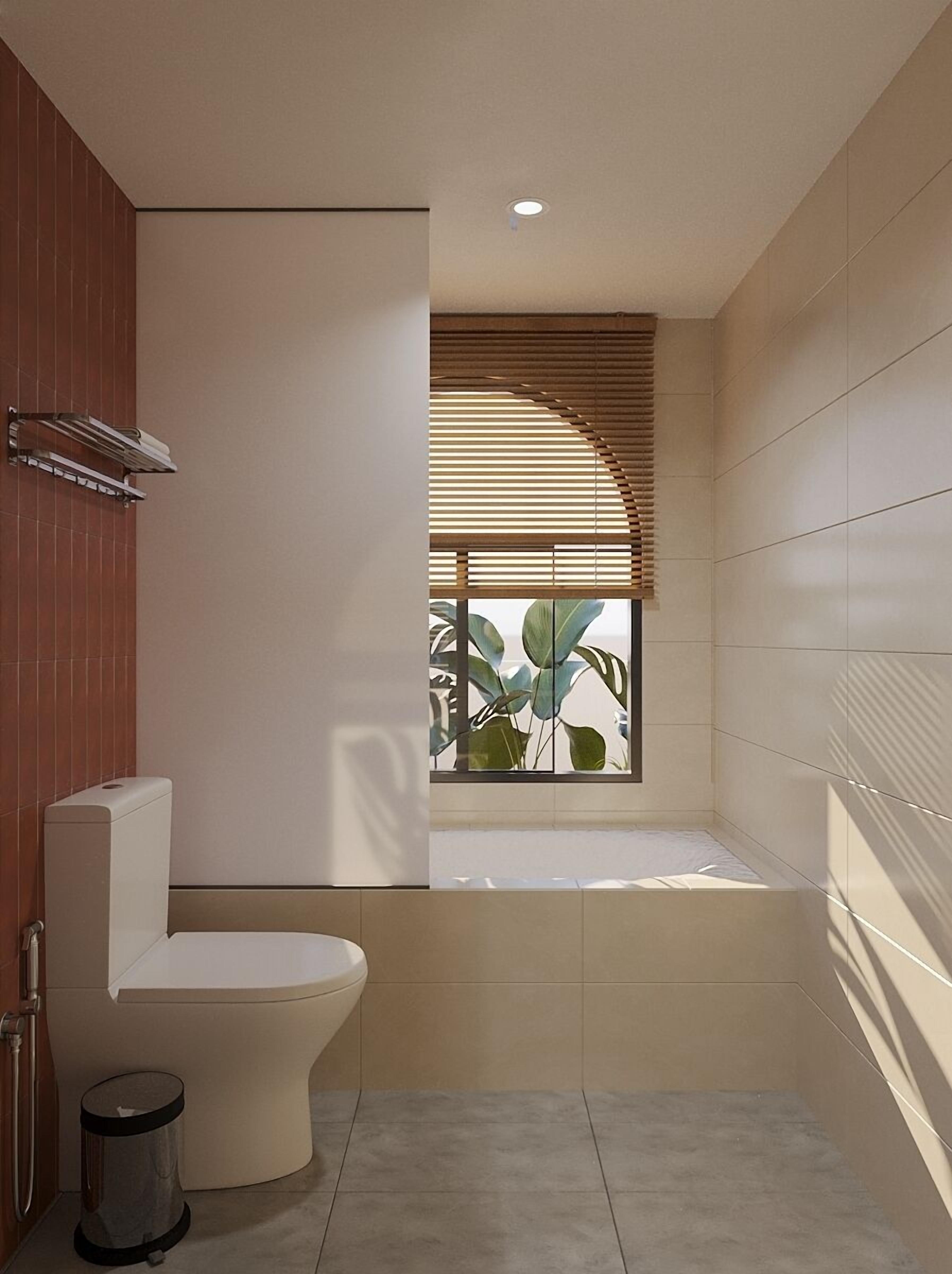 A modern bathroom with a toilet, a trash bin, and a window with blinds.