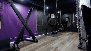 A room with purple walls, a wooden floor, and exercise equipment.
