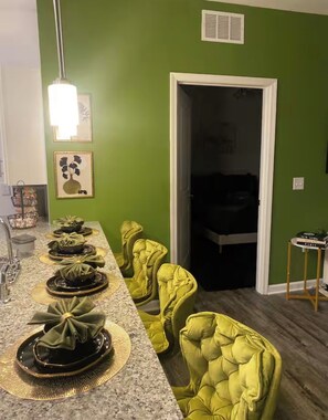 A dining area with a long table, green walls, and yellow chairs. - Charming Cozy 2-bedroom apartment in Jacksonville Florida (Jacksonville)