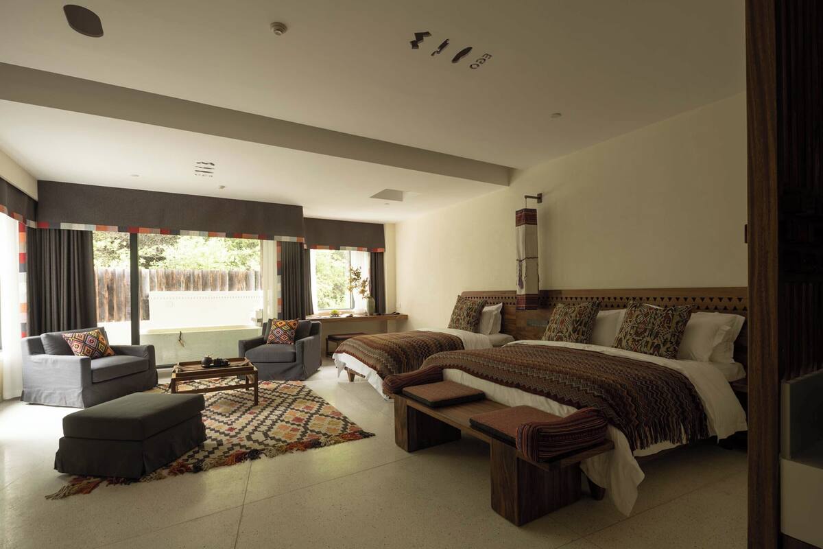A modern bedroom with a large bed, two bedside tables, a sofa, and a coffee table.