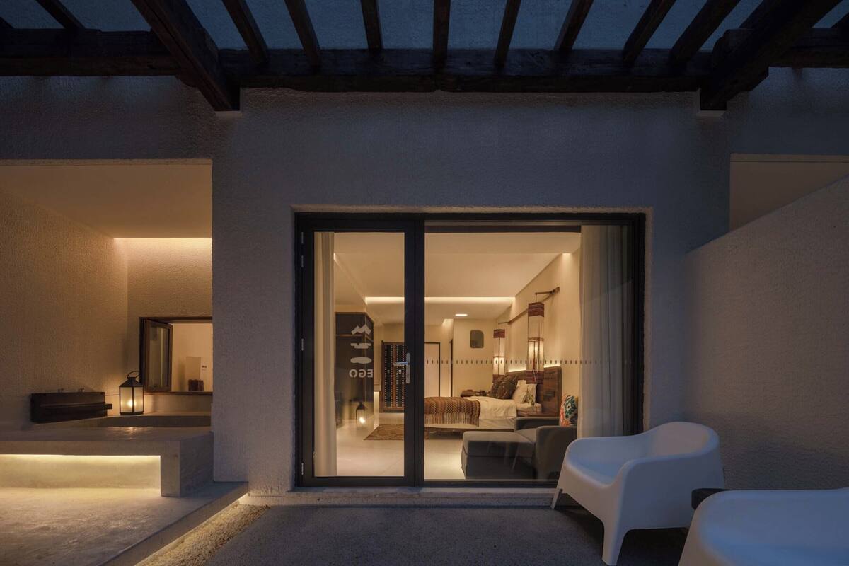 A modern interior with a glass door leading to a bedroom.