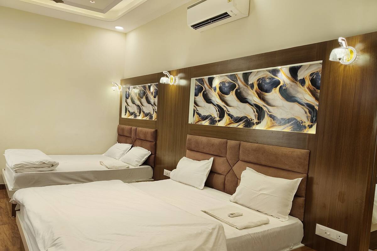 A hotel room with two beds, wooden headboards, and abstract wall art.