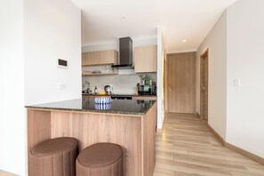 Departamento Deluxe, vista a la colina | Cocina privada | Parrilla de estufa y utensilios de cocina 