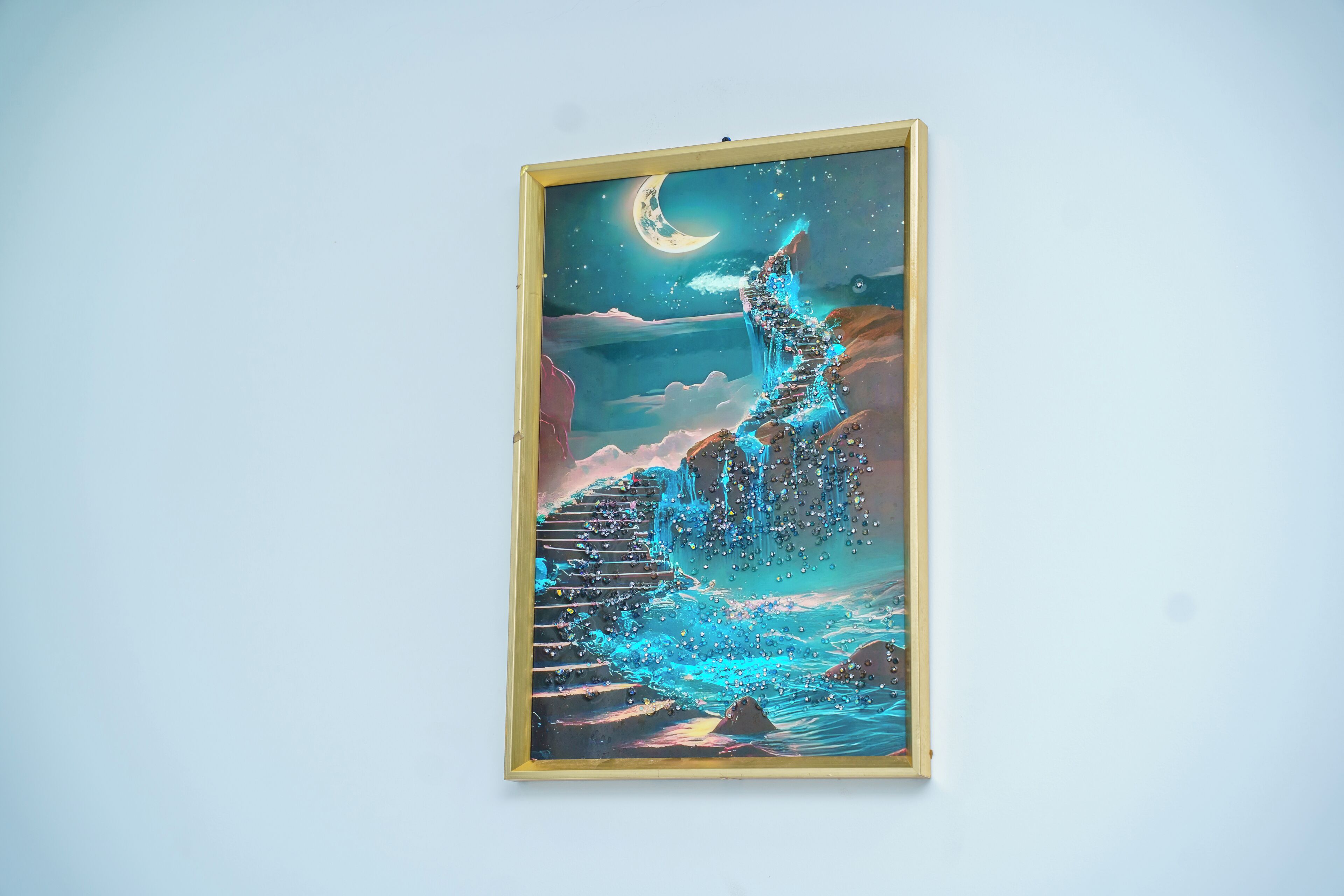 A framed artwork depicting a staircase leading up to a moonlit landscape.