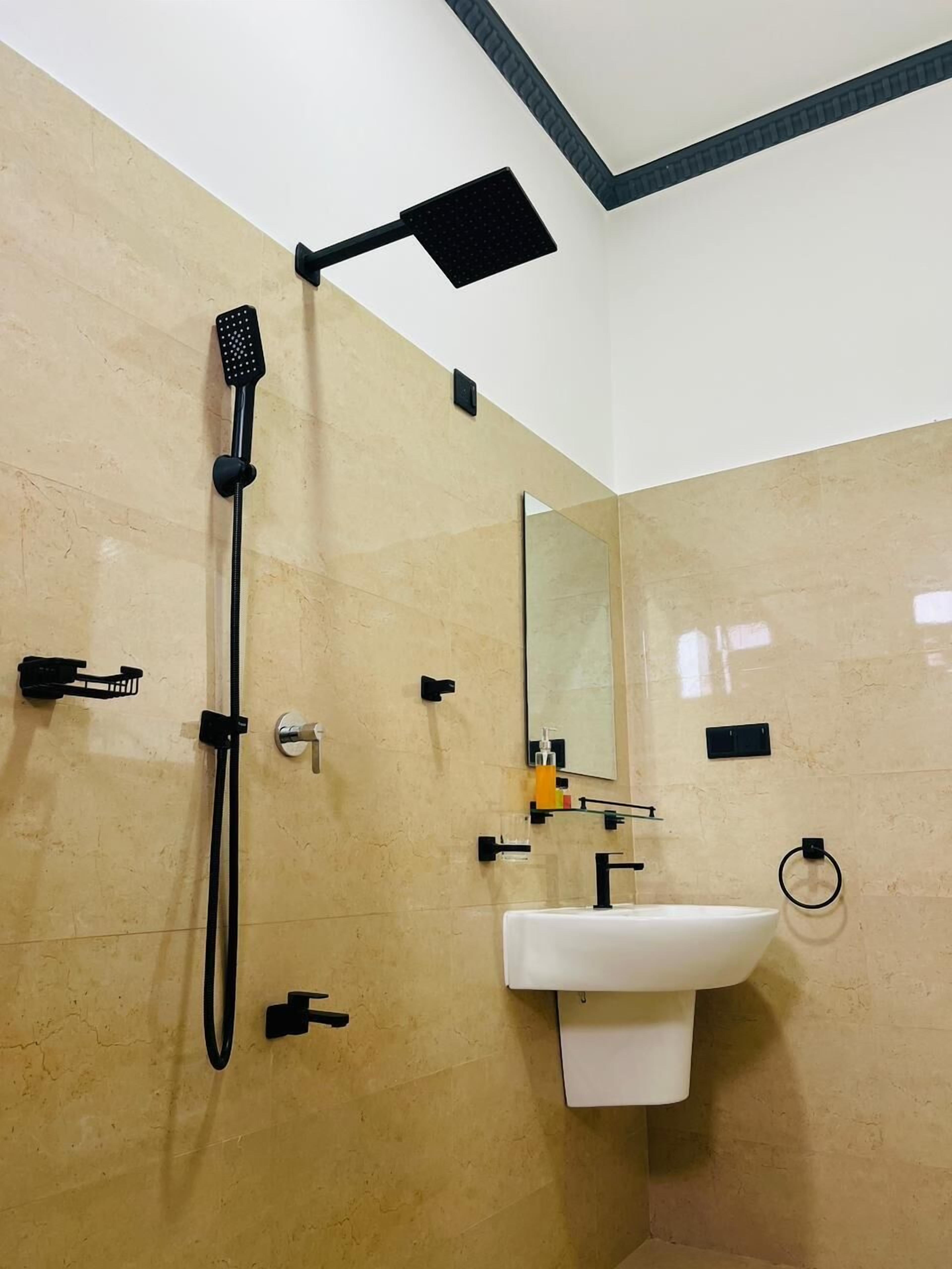 Een moderne badkamer met een douche, wastafel en spiegel.