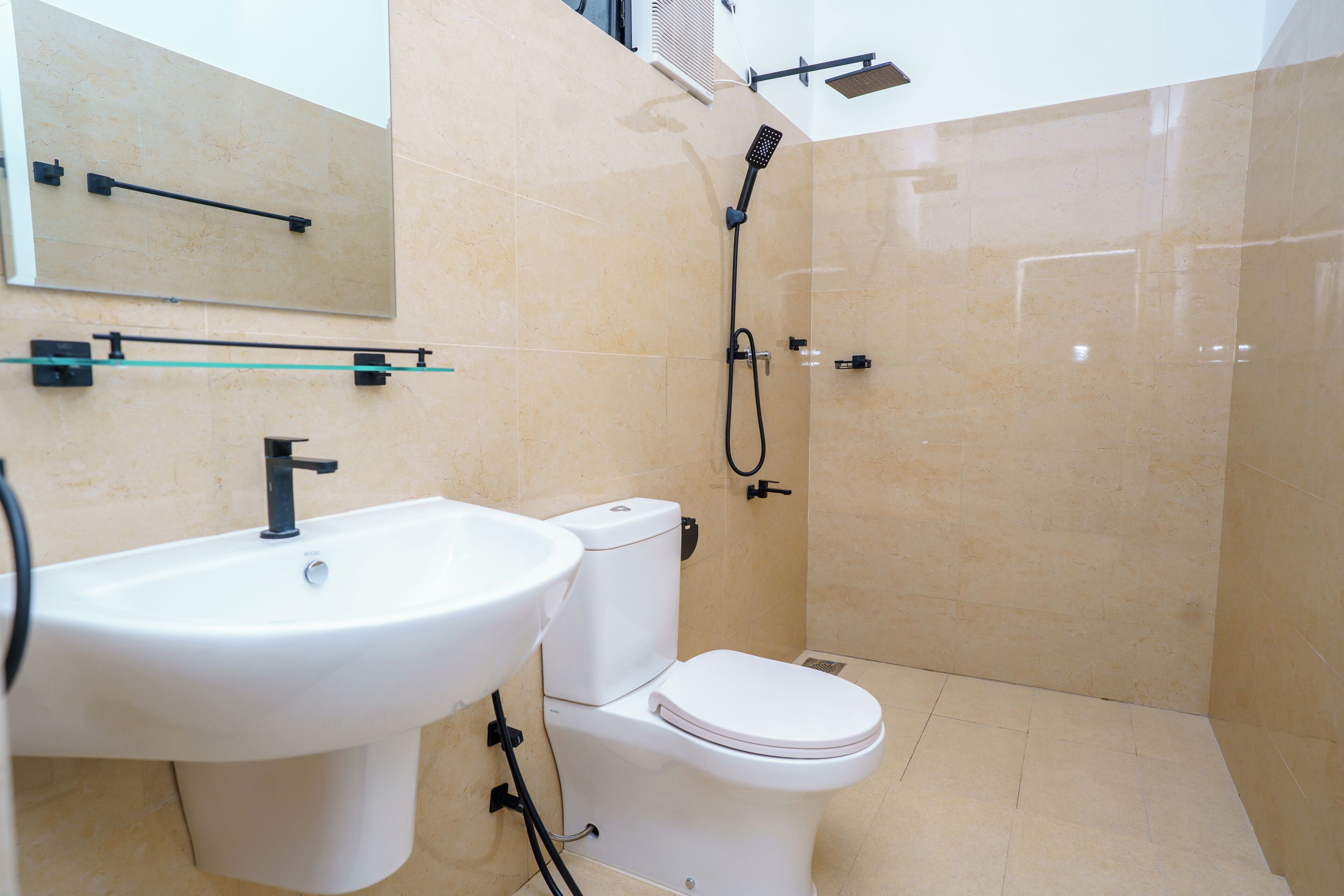 A modern bathroom with a sink, toilet, and shower.