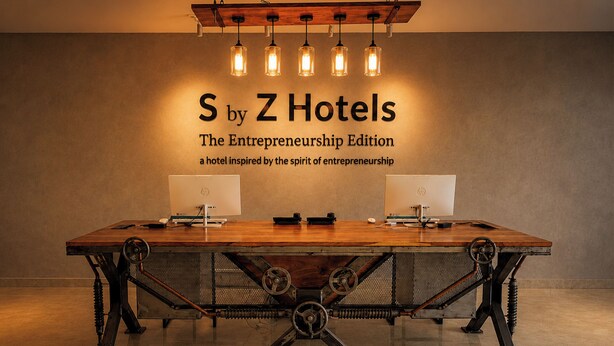 A conference table with two monitors, a wooden top, and a metal frame with springs. - S By Z Hotels HSR (Bengaluru)