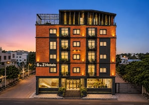 A multi-story hotel with a modern design, featuring balconies and large windows.