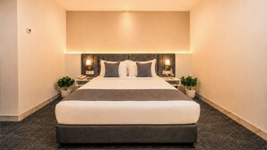 A modern hotel room with a large bed, two bedside tables with lamps, and potted plants. - S By Z Hotels HSR (Bengaluru)