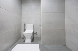 Une salle de bain moderne équipée de toilettes, d’une douche et d’un lavabo.