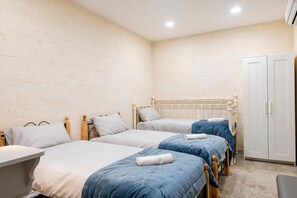 A room with three single beds, a wardrobe, and a small table. - Xlendi bay Wonderfull 3 bdr Apart Gozo (Munxar)