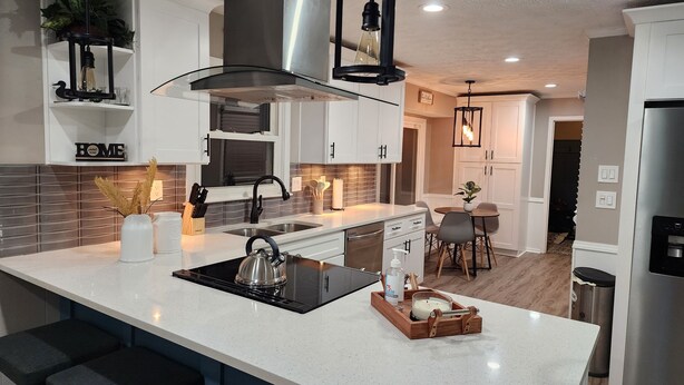 A modern kitchen with a central island, stainless steel appliances, and pendant lighting. - Stylish Lilburn/Stone Mountain Retreat w/Theater Room, Bar and 2nd Kitchen (Lilburn)