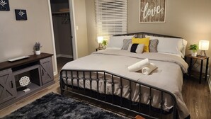 A bedroom with a bed, bedside tables, a desk, and a closet. - Stylish Lilburn/Stone Mountain Retreat w/Theater Room, Bar and 2nd Kitchen (Lilburn)