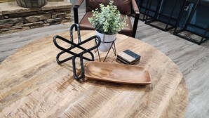 A round wooden table with a metal stand and a wooden tray. - Stylish Lilburn/Stone Mountain Retreat w/Theater Room, Bar and 2nd Kitchen (Lilburn)