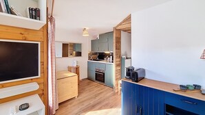 A compact kitchen with wooden cabinets, a microwave, and a coffee maker. - Okoume-Apartment-4pers-Proche center (Les Gets)