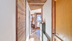 A wooden hallway with a view to a balcony and a window. - Okoume-Apartment-4pers-Proche center (Les Gets)