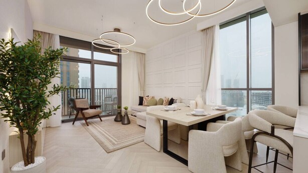 A modern dining area with a large table, chairs, and a potted plant. - Calm & Stylish 1Bedroom in Hadley Heights JVC (Jumeirah Village Circle (JVC))