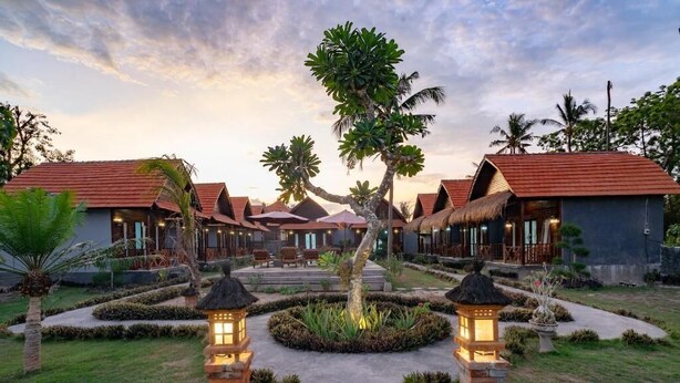 Een resort met meerdere bungalowgebouwen, een centrale looppad en verzorgde tuinen.