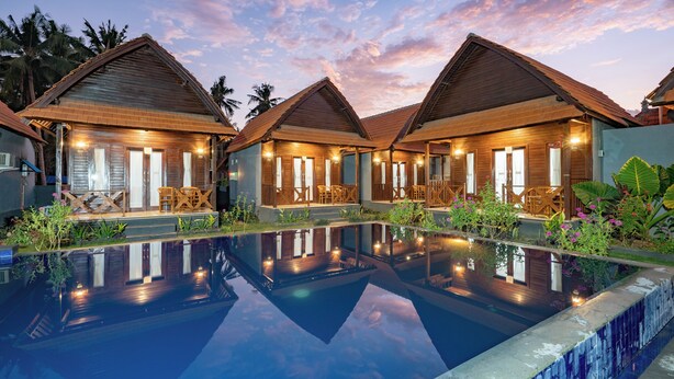 A resort with multiple wooden villas, each with a balcony and a pool. - Arjuna Bungalow (Penida Island)