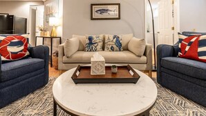 Een woonkamer met een zithoek, een salontafel en een lamp.