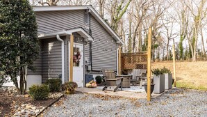 Een huis met een overdekte patio, buitenzitplaatsen en een grindpad.