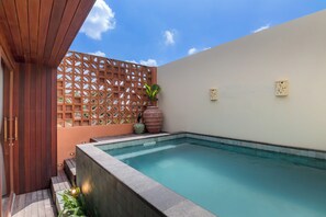 A swimming pool with a wooden deck and a decorative fence. - BLive Coliving Canggu (Canggu)