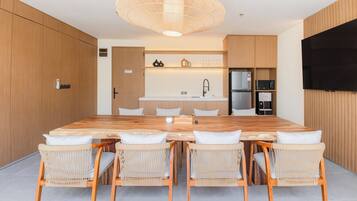 A modern kitchen with a central island, wooden cabinets, and a built-in TV.