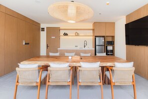Une cuisine moderne dotée d’un îlot central, de meubles en bois et d’un téléviseur encastré.