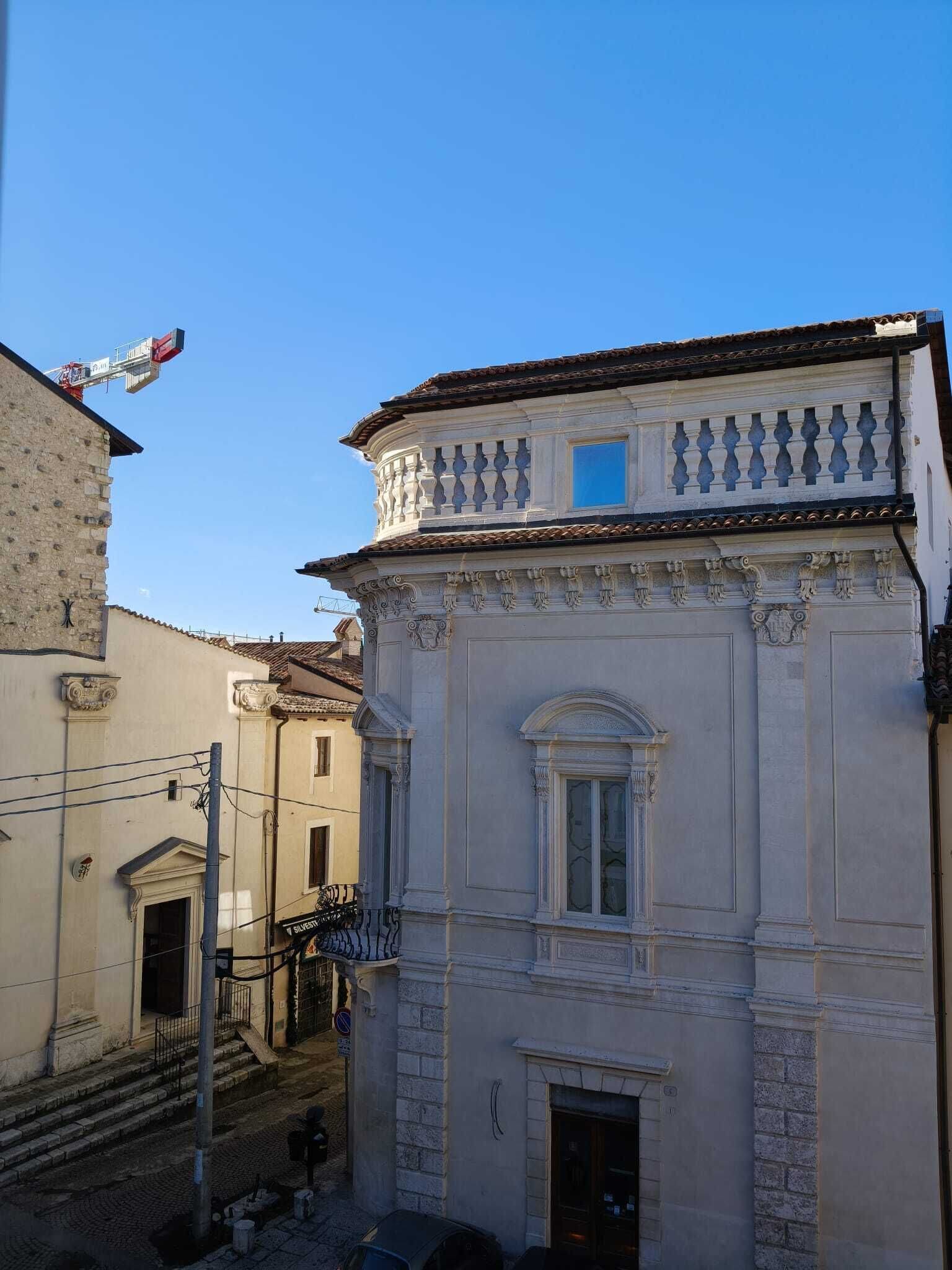A historic building with a balcony and a small window.