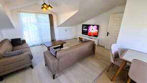 Een moderne woonkamer met een bank, een salontafel en een televisie.