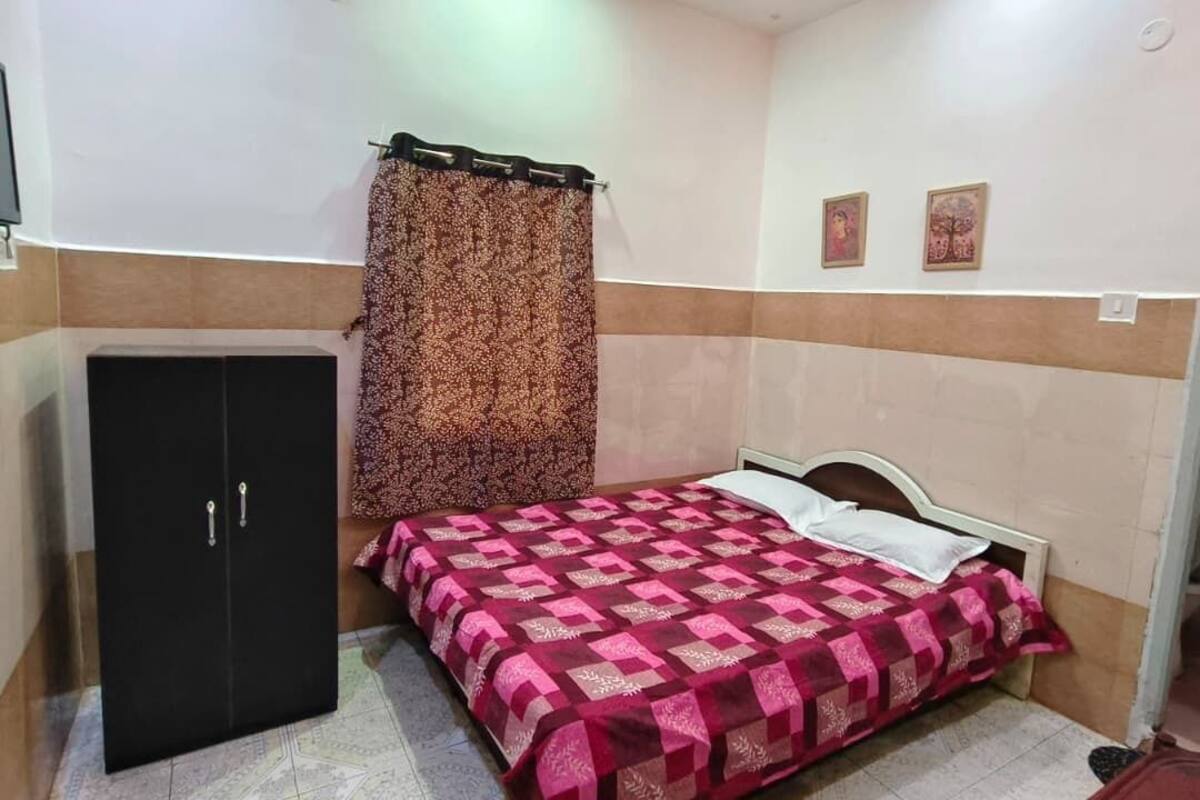 Un dormitorio con cama, armario y cortina.