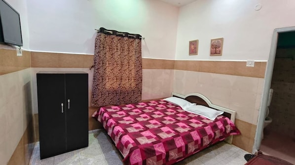 A bedroom with a bed, a wardrobe, and a curtain. - Maa Durga Guest Inn (Digha)