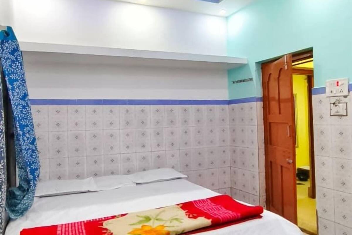 Un dormitorio con una cama, un ventilador de techo y una puerta.