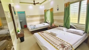 Une chambre d’hôtel avec deux lits, une salle de bain, un ventilateur de plafond et une fenêtre avec des rideaux.