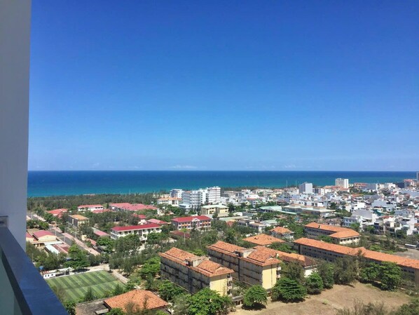 Eine Küstenstadt mit Gebäuden, blauem Himmel und dem Meer im Hintergrund.