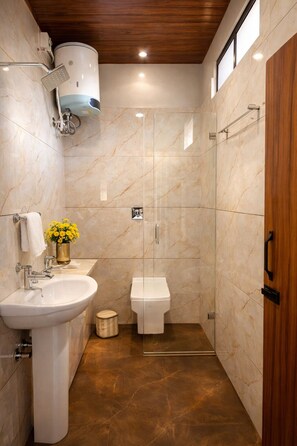 Deluxe tweepersoonskamer | Badkamer | Een douche, handdoeken, zeep, shampoo